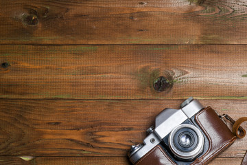 Old retro camera on vintage wooden boards abstract background. Copy space for text