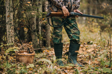 Male hunter in the autumn forest. A man holding a gun.