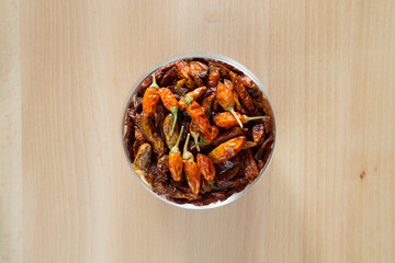 Peperoncini secchi rossi in contenitore di vetro su tavolo di legno