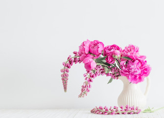 Peony flowers in vase on white background