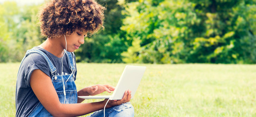 Young student girl with laptop at the park.