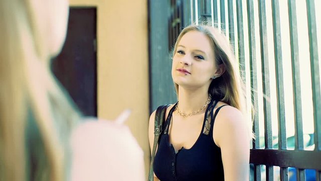 Punk girl smoking cigarette and talking with her friend
