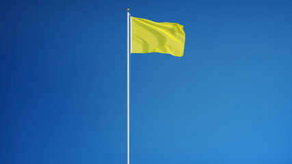 Bright yellow flag waving against clean blue sky, long shot, isolated with clipping path mask alpha channel transparency