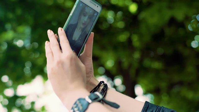Punk girl holding her smartphone and doing selfies on it
