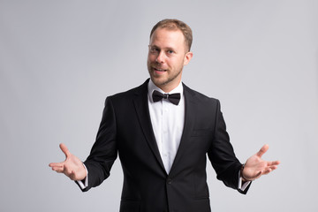 Handsome businessman in classic suit on gray background make explain gesture