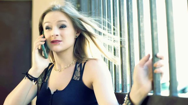 Punk girl talking on cellphone and looking very irritated

