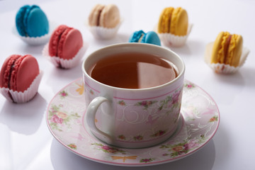 multicolored macaroon and a cup of tea