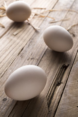 White eggs on old wooden table. Peasant life.