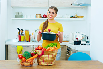 Beautiful woman cooking healthy food in home kitchen.