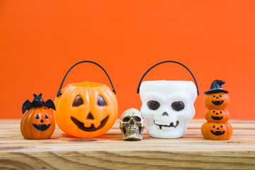 Halloween decoration on wooden table over orange background