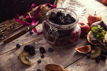Colorful fruit salad in a jar on rustic wooden background