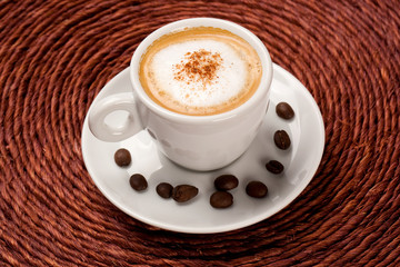 Cup of coffee with some beans around.
