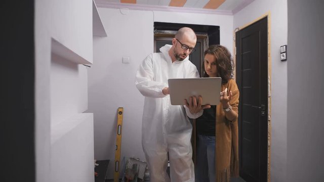 Professional work molar glasses and a client young girl, looking at the laptop screen design examples. People choose a project and discuss its details with the help of Computers and Internet