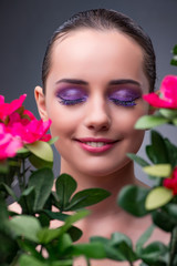 Young woman with flowers in beauty concept