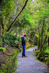 Obraz premium Father is carrying little daughter on his shoulders. Haast, South Island, New Zealand