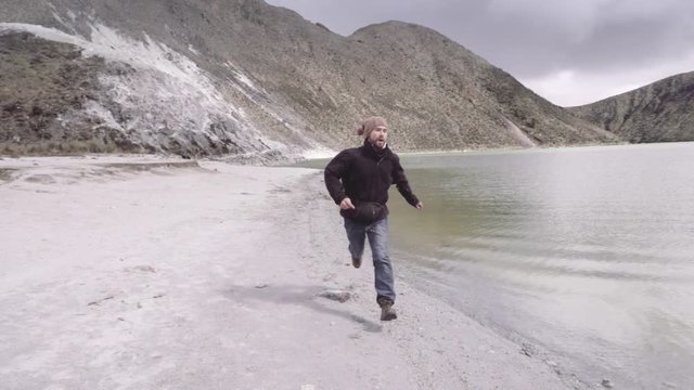 Man runs away from the sulphur lake on the volcano Los Azufrales, Colombia. Slow motion 