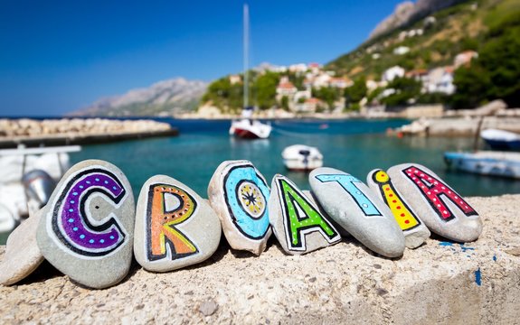 Croatia country name painted on the stones, boat in background