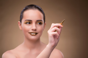 Woman with golden pen in fashion concept