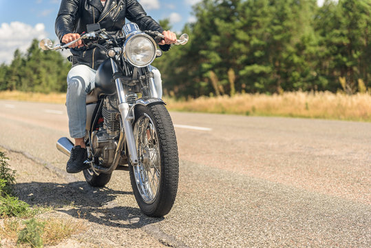 Young man riding his motorbike on open road