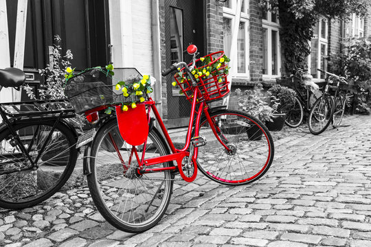 Retro vintage red bicycle on cobblestone street in the old town.