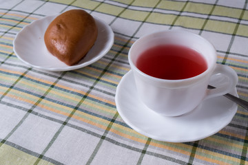 White Cup with fruit tea and cake in the plate