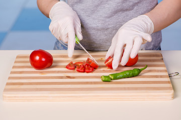 Hands of cook preparing salad