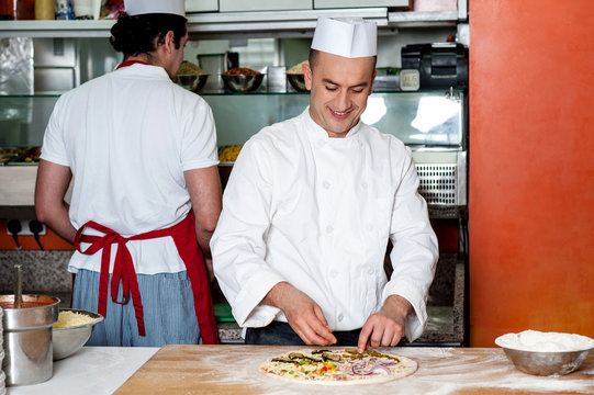 Male chef preparing the pizza