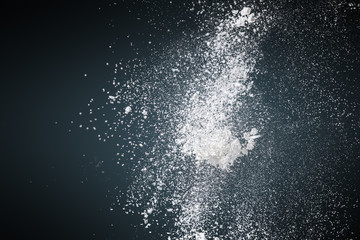 Abstract white powder against dark background