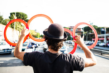 street juggler entertains motorists at traffic lights with red rings