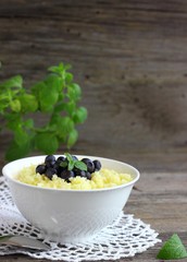 Maize porridge in bowl  with blueberries and mint. Healthy breakfast with vitamins.