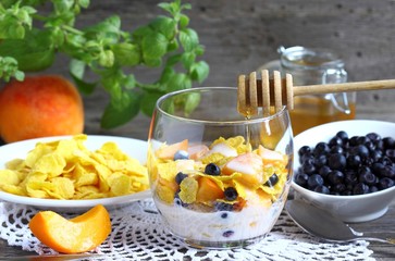 Maize porridge in bowl  with blueberries with  peach,  and mint. Healthy breakfast with vitamins.