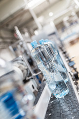 Water bottling line for processing and bottling pure spring water into bottles. Selective focus.