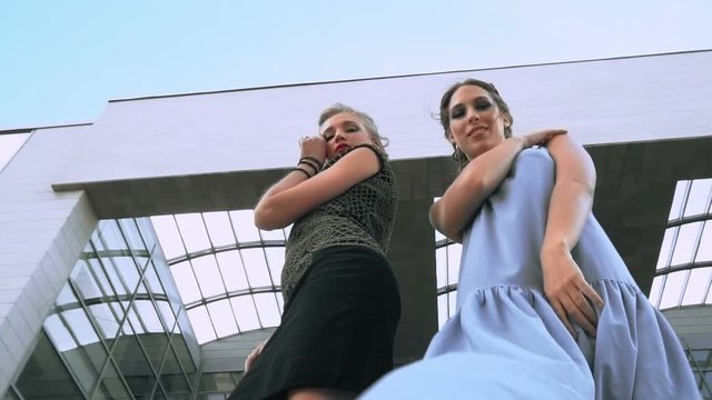 The girls posing together and whirling in front of camera with down angle