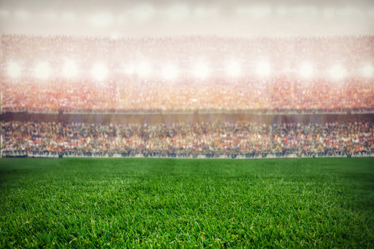 green grass stadium on supporters background