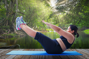 asian fat woman take v shape six pack course in the morning on wooden platform outdoor