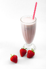 Strawberry ice cream milkshake drink in a vintage glass with a striped straw with fresh strawberries around isolated on white background