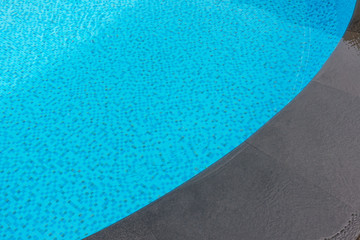 Blue swimming pool rippled water .