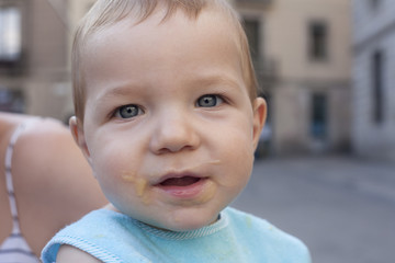 baby boy with mouth full of food after having fruit mush