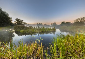 Foto op Canvas Marshland river system under foggy morning sunrise © creativenature.nl