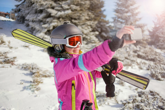 Happy woman taking selfie on winter mountain