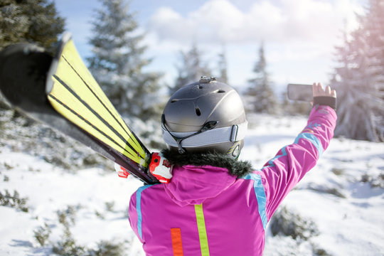 Happy woman taking selfie on winter mountain