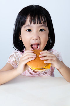 Happy Asian Chinese little girl Eating Burger