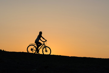 Fototapeta na wymiar Cyclist Girl on beautiful sunset.
