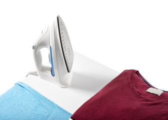 ironing, clothes, housework and objects concept - close up of iron and clothes on table