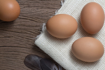 chicken eggs with sackcloth on old wooden top