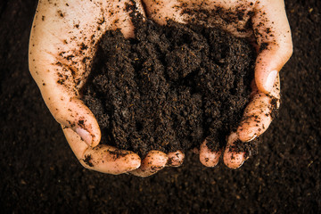 Hands dirty with clay , soil background