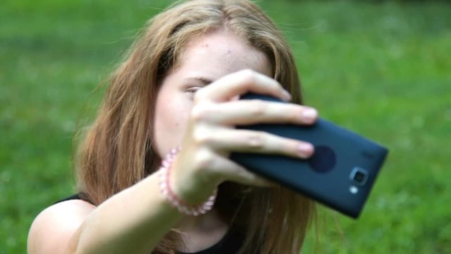 Close-up shot of a teengaer girl taking selfie with mobile outdoor