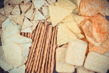 Vintage photo, Heap of salted crisps, breadsticks and cookies, concept of unhealthy food