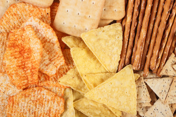 Heap of salted crisps, breadsticks and cookies, concept of unhealthy food