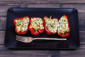 Stuffed red peppers in black plate